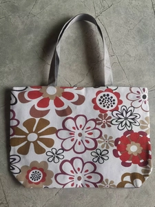 Flat lay detail of canvas tote bag featuring vintage floral prints and grey handles