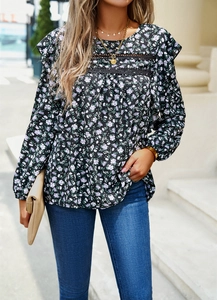 Detail of floral chiffon blouse with lace trim and elegant ruffles on a black base