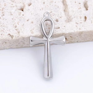 Polished silver stainless steel Ankh cross pendant on textured stone background