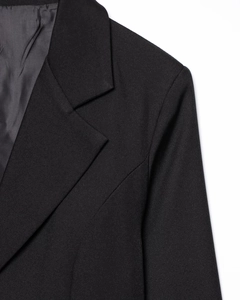 Close-up of the professional lapel and shoulder stitching on a black blazer jacket