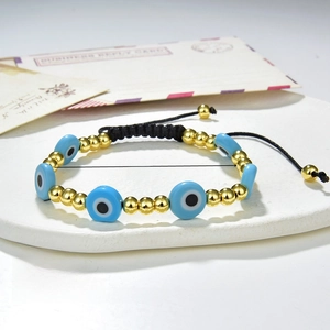 Detail of 5mm evil eye beads and golden copper beads with adjustable braided cord