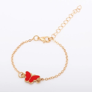 Close-up of golden adjustable chain bracelet with a vibrant red butterfly charm and lobster clasp