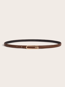 Detailed view of slim brown leather belt featuring a polished golden G-shaped buckle