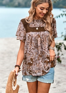 Detail of floral print top with lace panels and ruffled sleeves for beach vacation