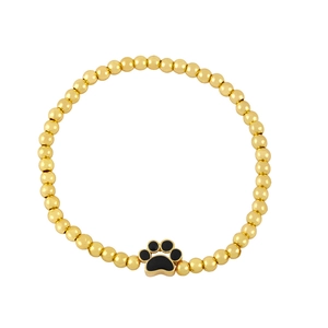 Macro detail of gold beaded bracelet featuring a black paw print charm pendant