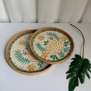 Detail of round rattan trays featuring floral mosaic patterns and woven bamboo edges