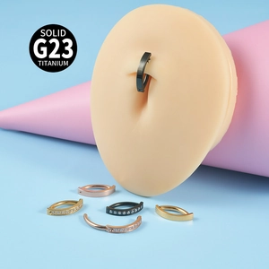Detail of G23 titanium belly rings in various finishes shown on a silicone model skin