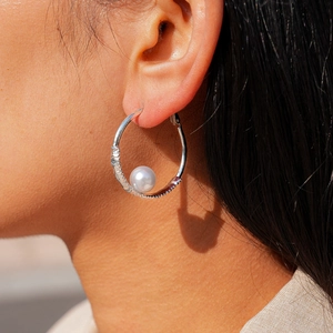 Elegant geometric silver hoop earring with white pearl accent and textured metal finish