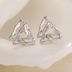 Symmetric silver hollow triangle earrings with 18K gold plating and zircons on ceramic tray