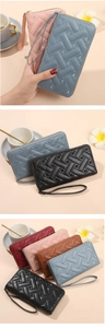 Detail of woven texture and heart embroidery on a long zip-around women's wallet