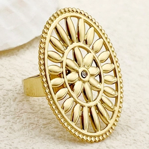 Macro shot of gold plated oval ring featuring hollow sunflower design and small zircon