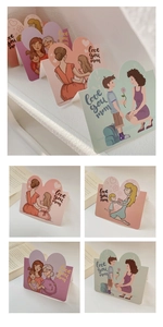 Detail of heart-shaped greeting cards featuring warm mother and child illustrations