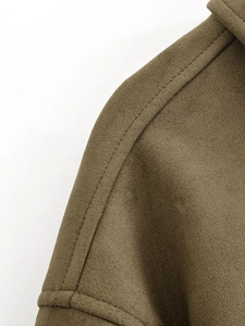 Vue détaillée des coutures doubles sur l'épaule d'une veste en daim vert olive