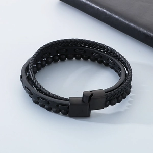Detail of men's multilayer black leather bracelet with tiger eye beads and matte metal clasp