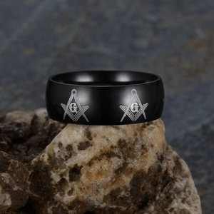 Black matte stainless steel Freemason ring with G letter on a stone background