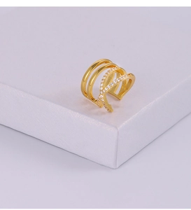 Détail d'une manchette d'oreille dorée multicouche avec zircons sur support blanc