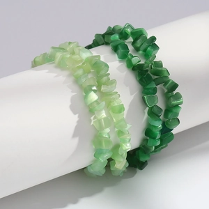 Detail of irregular cat-eye stone bead bracelets in light and dark green on a white display