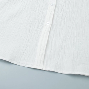 Close-up of white textured crinkle fabric with matching semi-transparent buttons