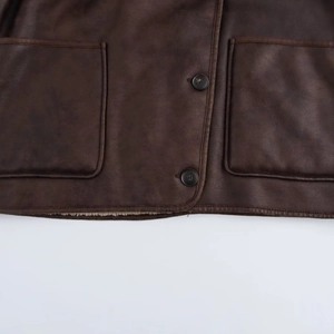 Detailed macro view of dark brown faux suede jacket featuring functional pockets and plush lining