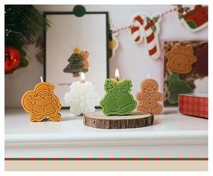 Cozy festive setup of scented Christmas candles featuring Santa and gingerbread man shapes