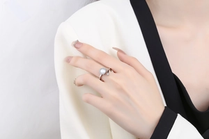 Close-up of a silver spinner ring with a central mother-of-pearl stone and micro-pave diamonds