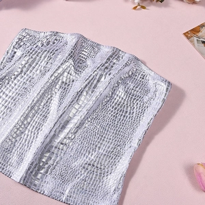Detail of silver crocodile texture tube top with metallic faux leather finish