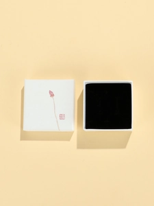 Detailed top view of minimalist jewelry gift box with lotus illustration and black lining