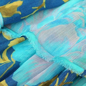 Deep blue layered chiffon tiered dress with vibrant floral print and ruffled detailing