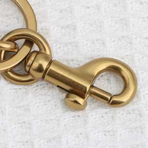 Makro-Detail des goldenen Karabinerverschlusses und Rings aus Metall auf Textilstoff