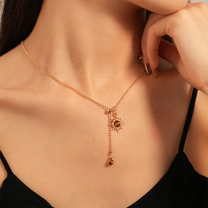 Detailed macro of vintage sun flower lariat necklace with tiger eye stone on a female model