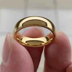 Minimalist gold-plated polished round band ring held by hand for jewelry display