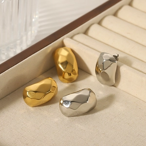 Irregular faceted geometric earrings in gold and silver finish inside a velvet jewelry box