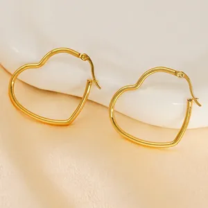 Boucles d'oreilles cœur en acier inoxydable plaqué or 18 carats sur fond de soie