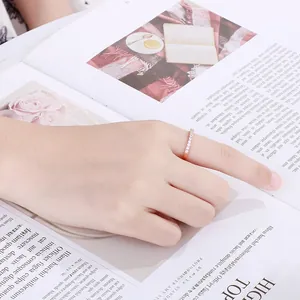 Nahaufnahme eines minimalistischen Roségold-Rings mit Zirkonia-Steinen am Finger getragen