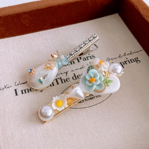 Detailed macro view of sweet rhinestone floral hair clips with pearls and resin charms