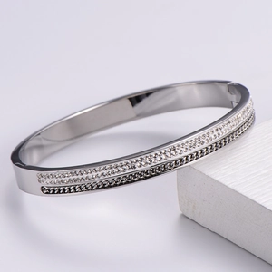 Close-up of silver bangle featuring triple-layer design with pavé crystals and black chain
