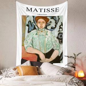Detail of Matisse art tapestry hanging on a cozy bedroom wall with warm lighting