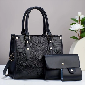 Detailed view of 3-piece black crocodile pattern handbag set with golden hardware accents