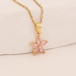 Close-up of pink zircon flower pendant on a gold geometric necklace for women