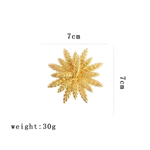 Vue détaillée d'une broche flocon dorée avec dimensions de 7cm et poids de 30g