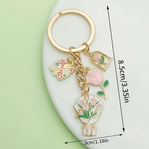 Gold keychain with pink enamel tulip and rose charms on white display stand