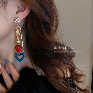 Chic tassel earrings with strawberry, star, and heart charms worn by a model