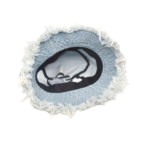 Detail view of denim bucket hat featuring frayed edges and internal adjustable drawstrings