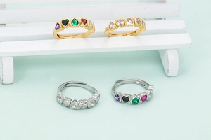 Detail of gold and silver open rings with colorful heart-shaped cubic zirconia stones