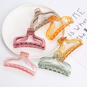 Macro shot of translucent hair claw clips in five pastel colors on a white tray