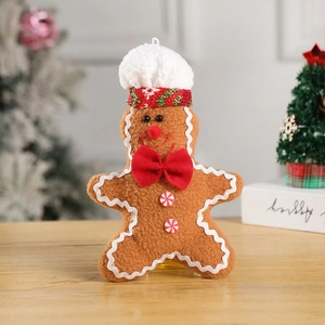 Close-up of plush gingerbread man with chef hat and bow tie for Christmas tree decor