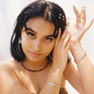 Close-up of Bohemian tiger eye beaded necklace with golden hoop earrings on a model