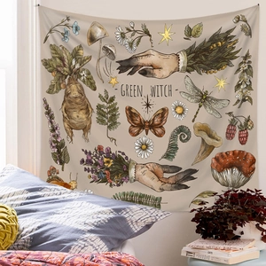 Bohemian Green Witch tapestry with mushroom illustrations hanging in a cozy bedroom