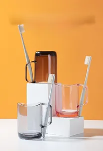 Close-up of translucent mouthwash cups with integrated toothbrush holders on white stands