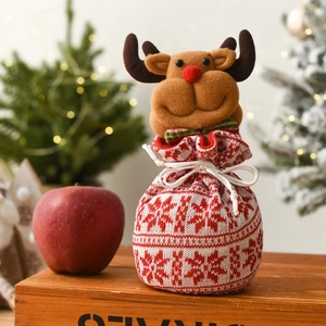 Detail of Christmas reindeer drawstring gift bag with knit snowflake patterns and plush antlers